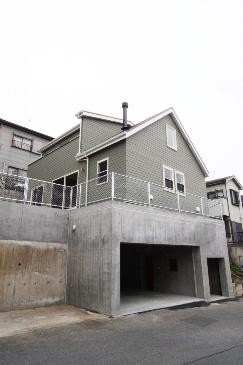 擁壁の上にアメリカンスタイルの家を載せた、サーフィンやアウトドアを子供と一緒に楽しむ住まい