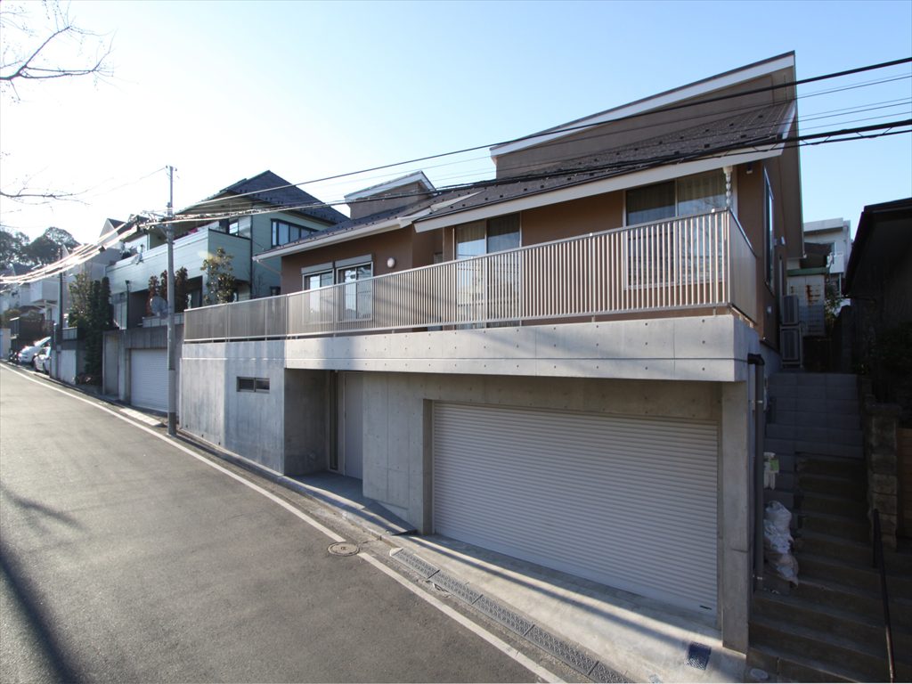 詳細不明な古い大谷石擁壁をRC造の擁壁玄関＋擁壁地下車庫に変えた住まい